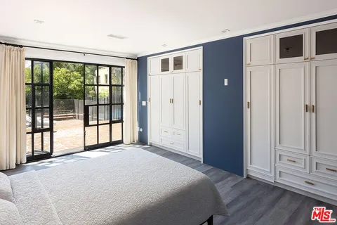 a spacious bedroom with a large bed and chandelier