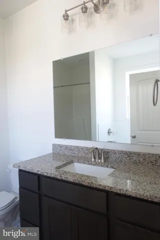 a bathroom with a granite countertop sink and a mirror
