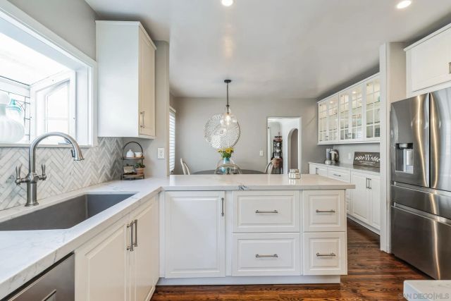 a kitchen with kitchen island white cabinets and stainless steel appliances