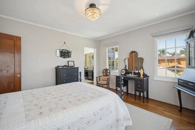 a bedroom with a bed and a desk in it with window