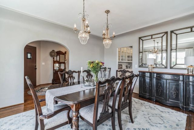 a dining room with furniture a chandelier and wooden floor