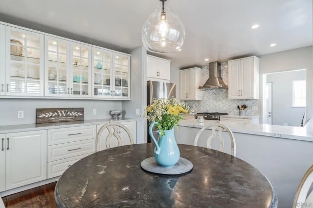a kitchen with a white stove top oven and white cabinets next to a window