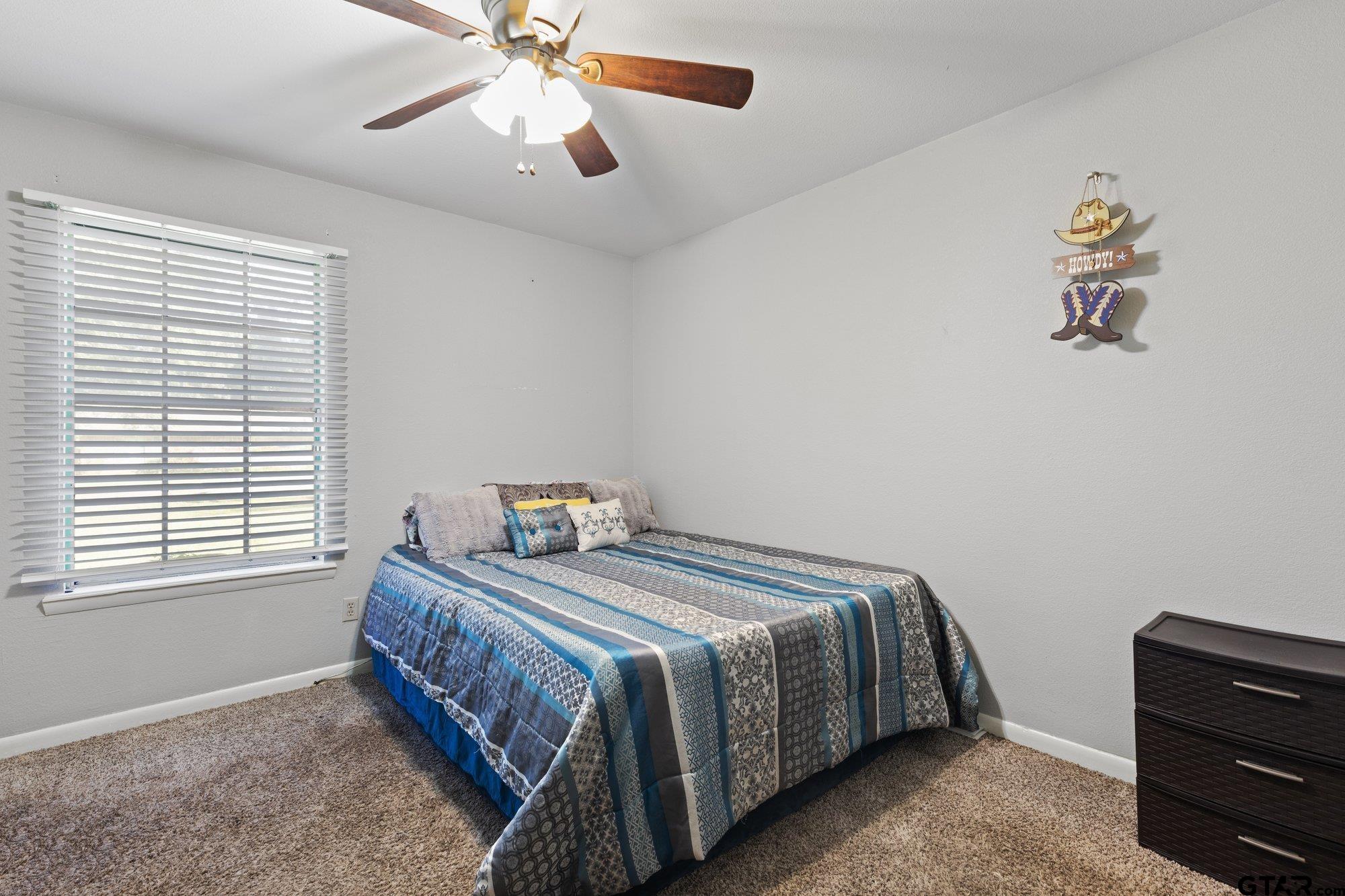 128 Amy Street Longview, TX 75605 - Photo 11 of 21 a bedroom with a bed and a chandelier