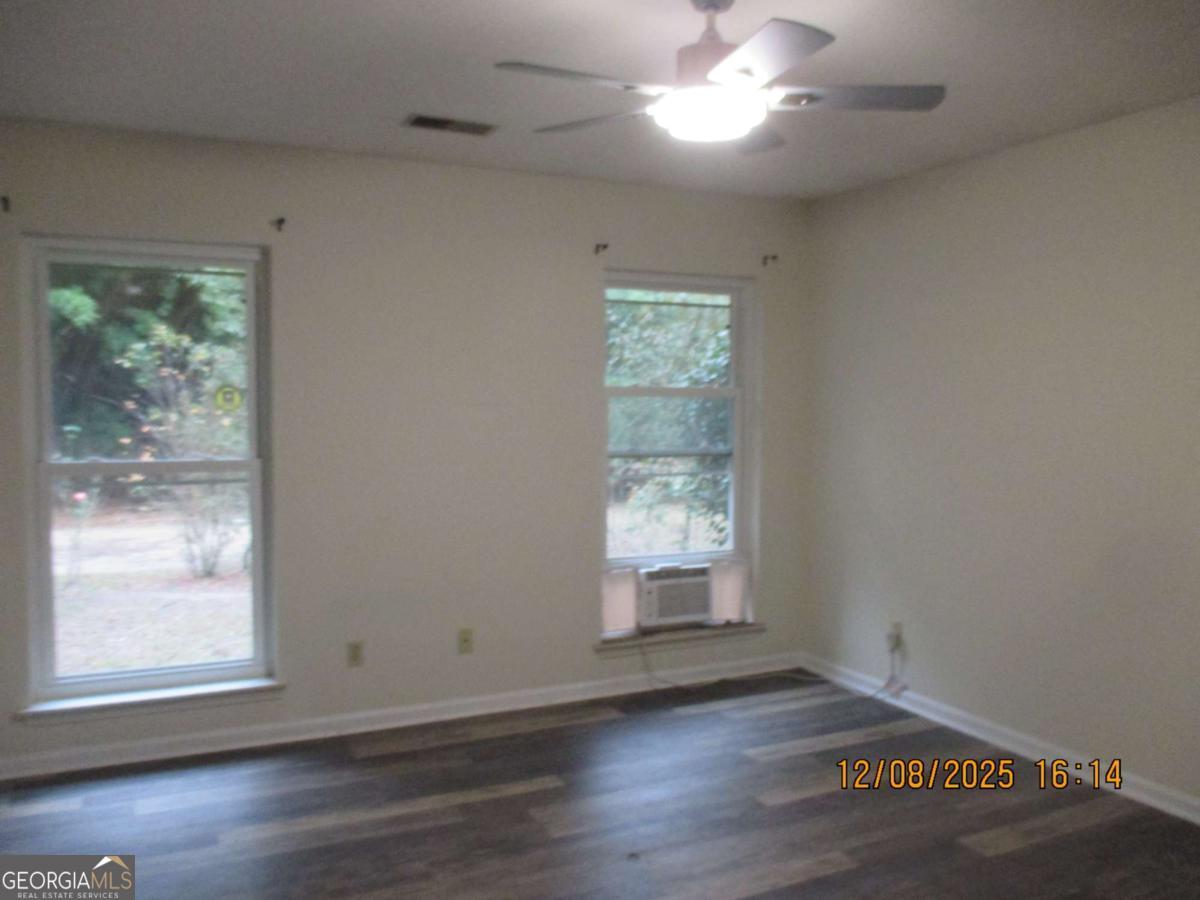 908 Kings Road Hinesville, GA 31313 - Photo 12 of 15 an empty room with wooden floor and windows