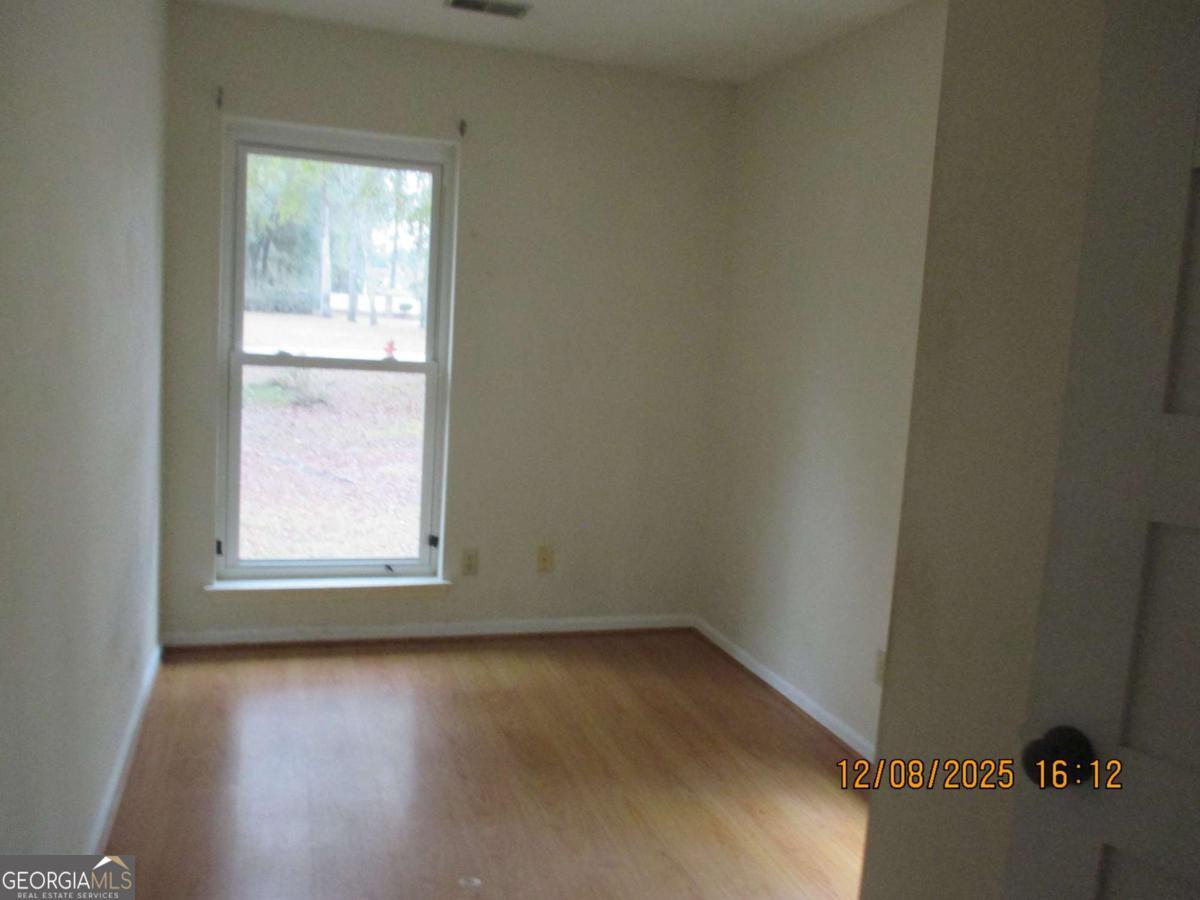 908 Kings Road Hinesville, GA 31313 - Photo 7 of 15 an empty room with wooden floor and windows