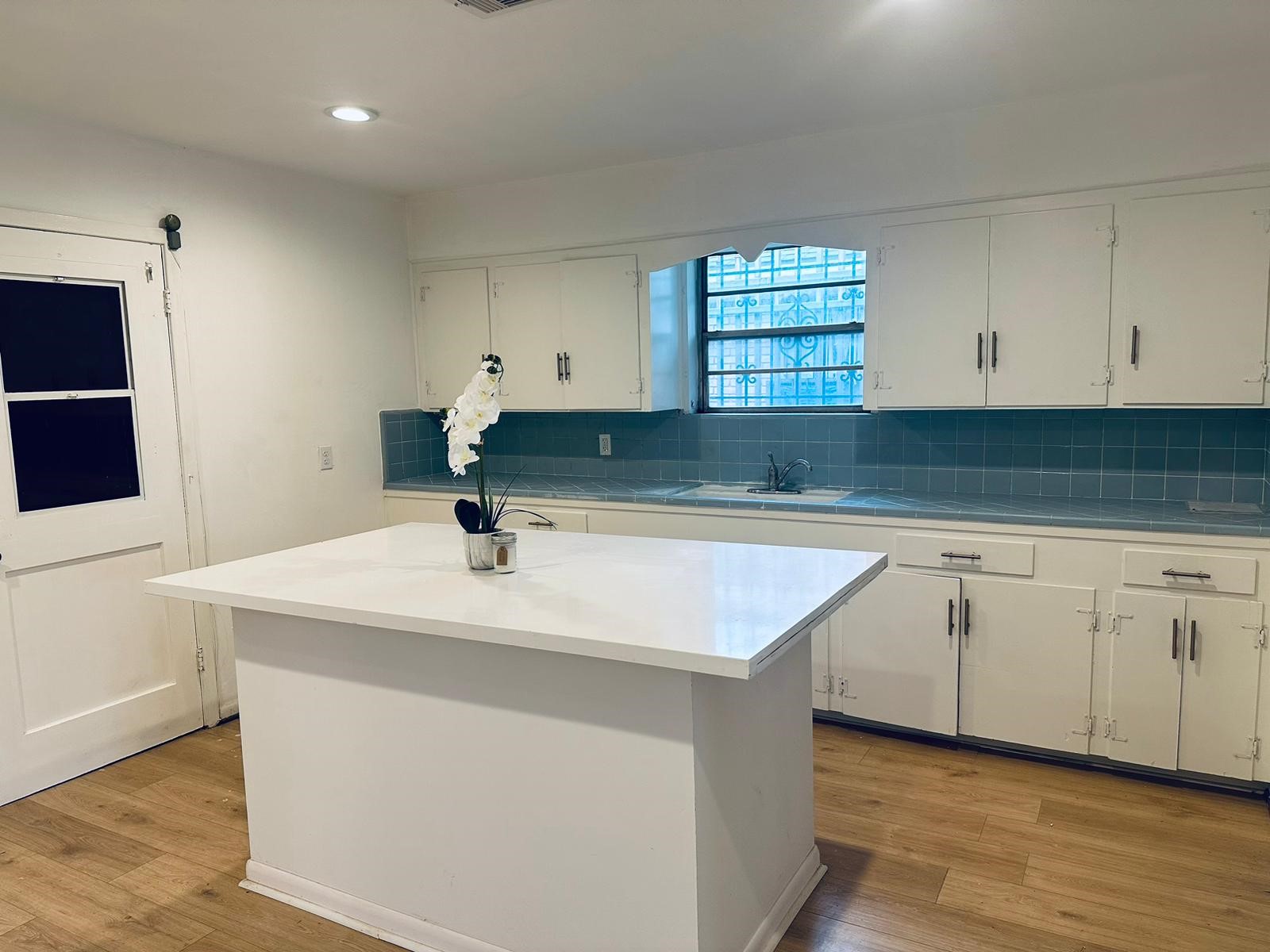 a kitchen with granite countertop white cabinets and a sink
