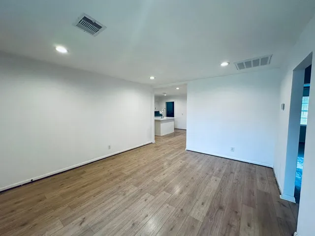 a view of empty room with wooden floor