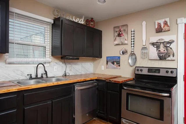 a kitchen with stainless steel appliances a stove sink and cabinets