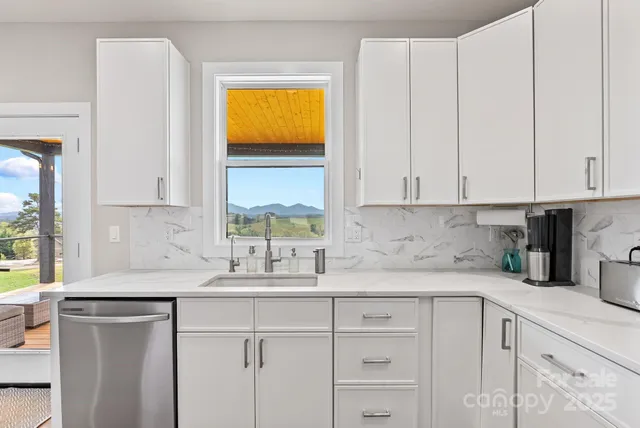 a kitchen with stainless steel appliances white cabinets and a sink