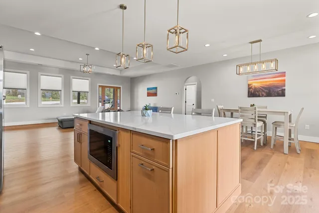 a kitchen with stainless steel appliances granite countertop a sink a stove and a wooden floors