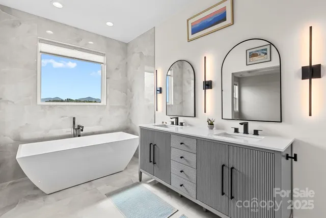 a spacious bathroom with a double vanity sink mirror and bathtub