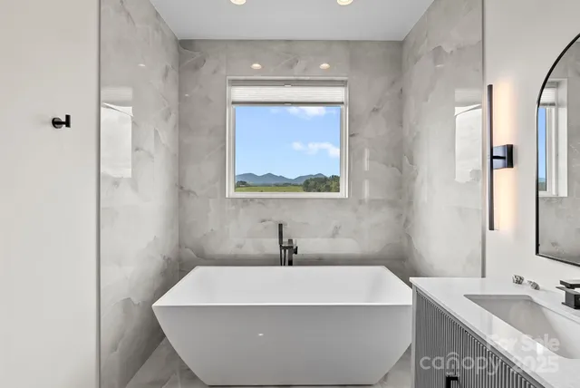 a white bath tub sitting in a bathroom next to a window
