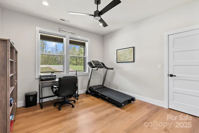 a view of a workspace with furniture and a window