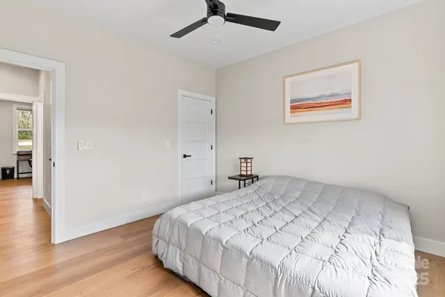 a bedroom with a bed and wooden floor