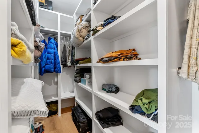 a view of walk in closet with clothes and shoes