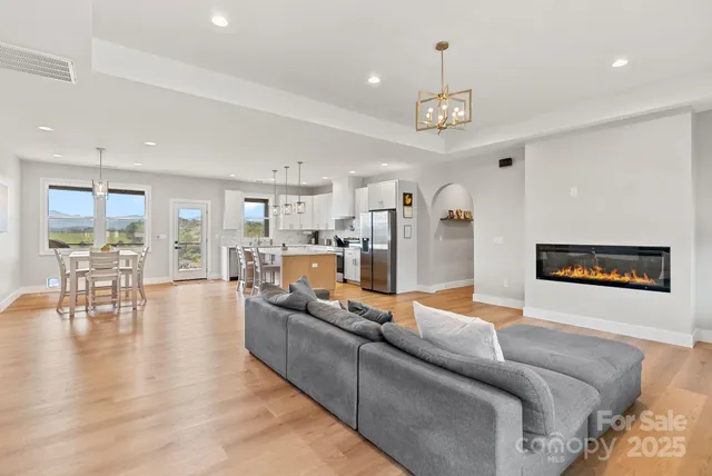 a living room with furniture wooden floor and a chandelier
