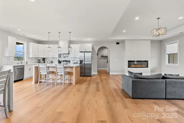 a living room with stainless steel appliances kitchen island granite countertop a living room and couches with kitchen view