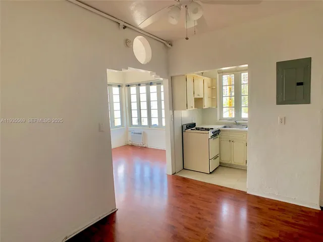 a view of a kitchen with a sink and dishwasher with wooden floor