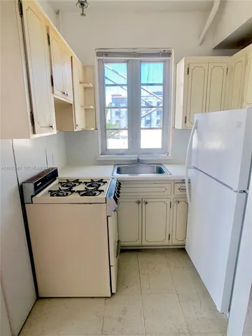 a kitchen with a white stove top oven and refrigerator