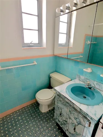 a bathroom with a sink toilet and mirror