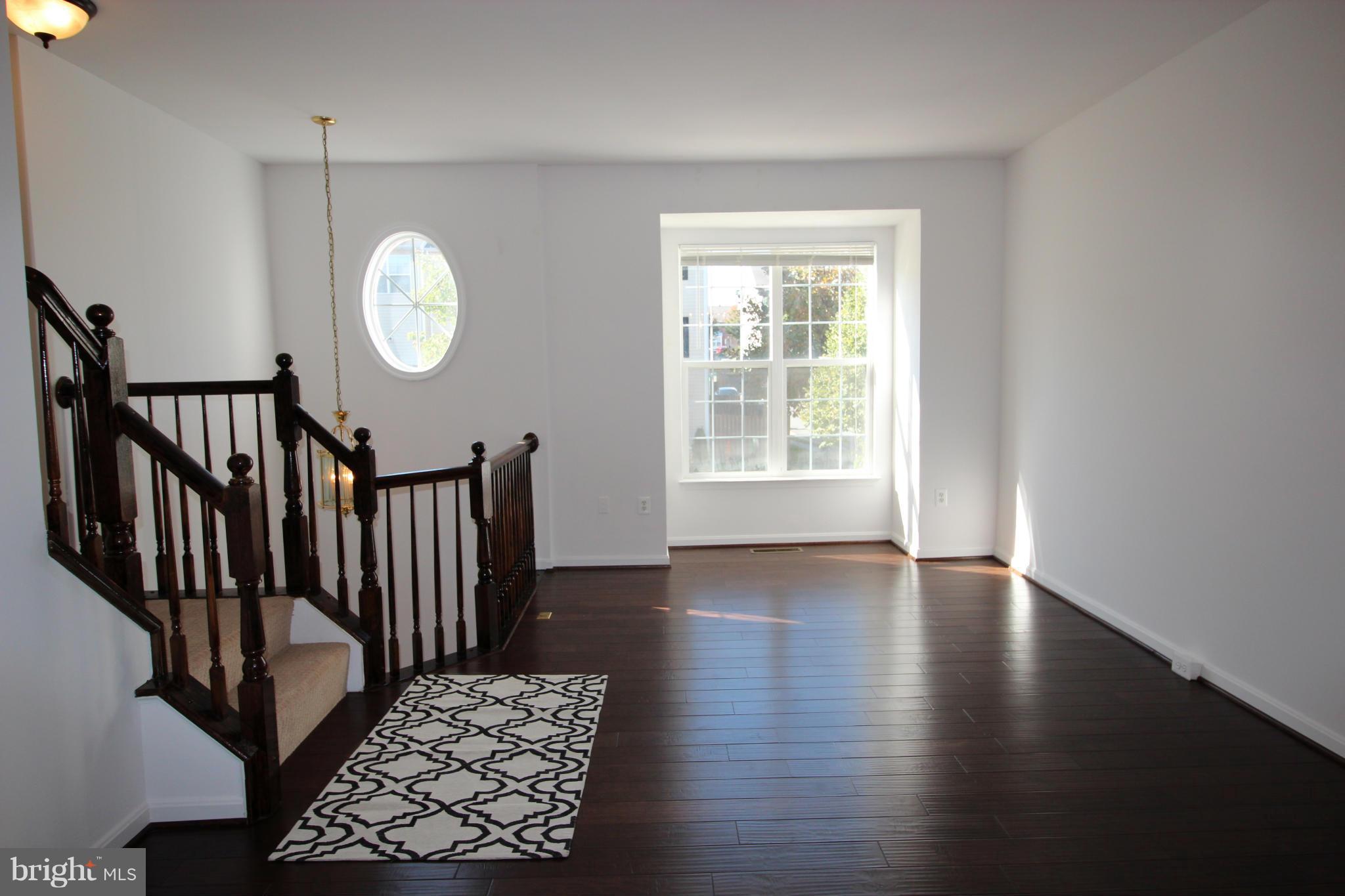 10556 Falkirk Way Manassas, VA 20109 - Photo 9 of 23 an empty room with wooden floor windows and a way to kitchen