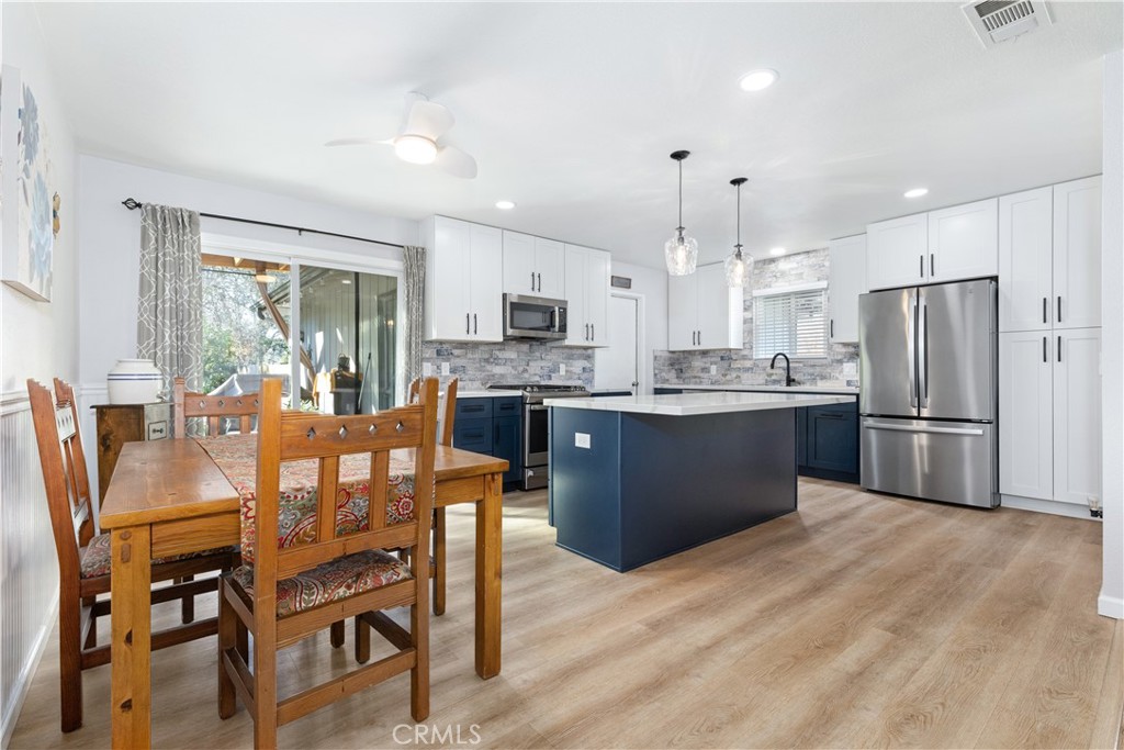 8425 Azucena Avenue Atascadero, CA 93422 - Photo 11 of 47 a kitchen with stainless steel appliances a dining table chairs refrigerator and microwave