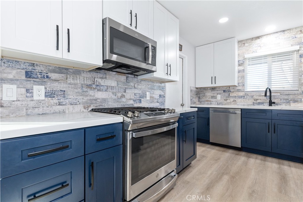 8425 Azucena Avenue Atascadero, CA 93422 - Photo 14 of 47 a kitchen with stainless steel appliances granite countertop a sink dishwasher stove and microwave with wooden cabinets