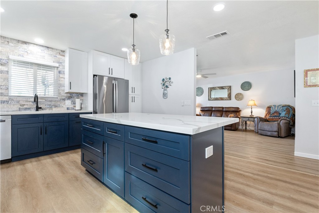 8425 Azucena Avenue Atascadero, CA 93422 - Photo 16 of 47 a kitchen with granite countertop a sink dishwasher a stove and a refrigerator with wooden floor