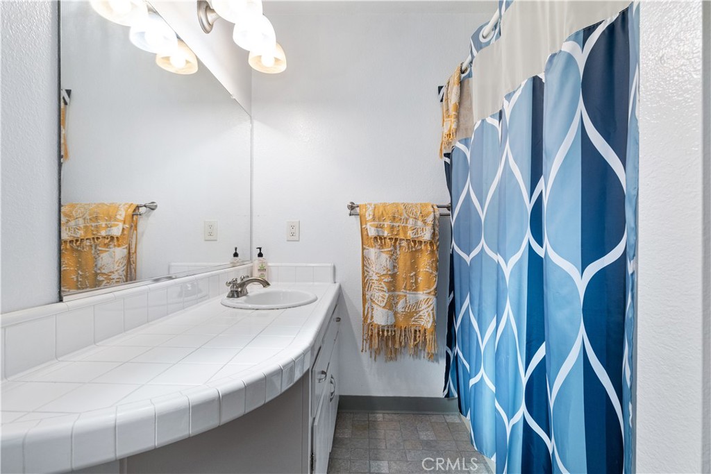 8425 Azucena Avenue Atascadero, CA 93422 - Photo 30 of 47 a bathroom with a sink a mirror and shower