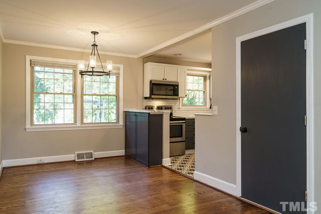 141 Lord Ashley Road Raleigh, NC 27610 - Photo 8 of 28 an empty room with wooden floor a ceiling fan and windows