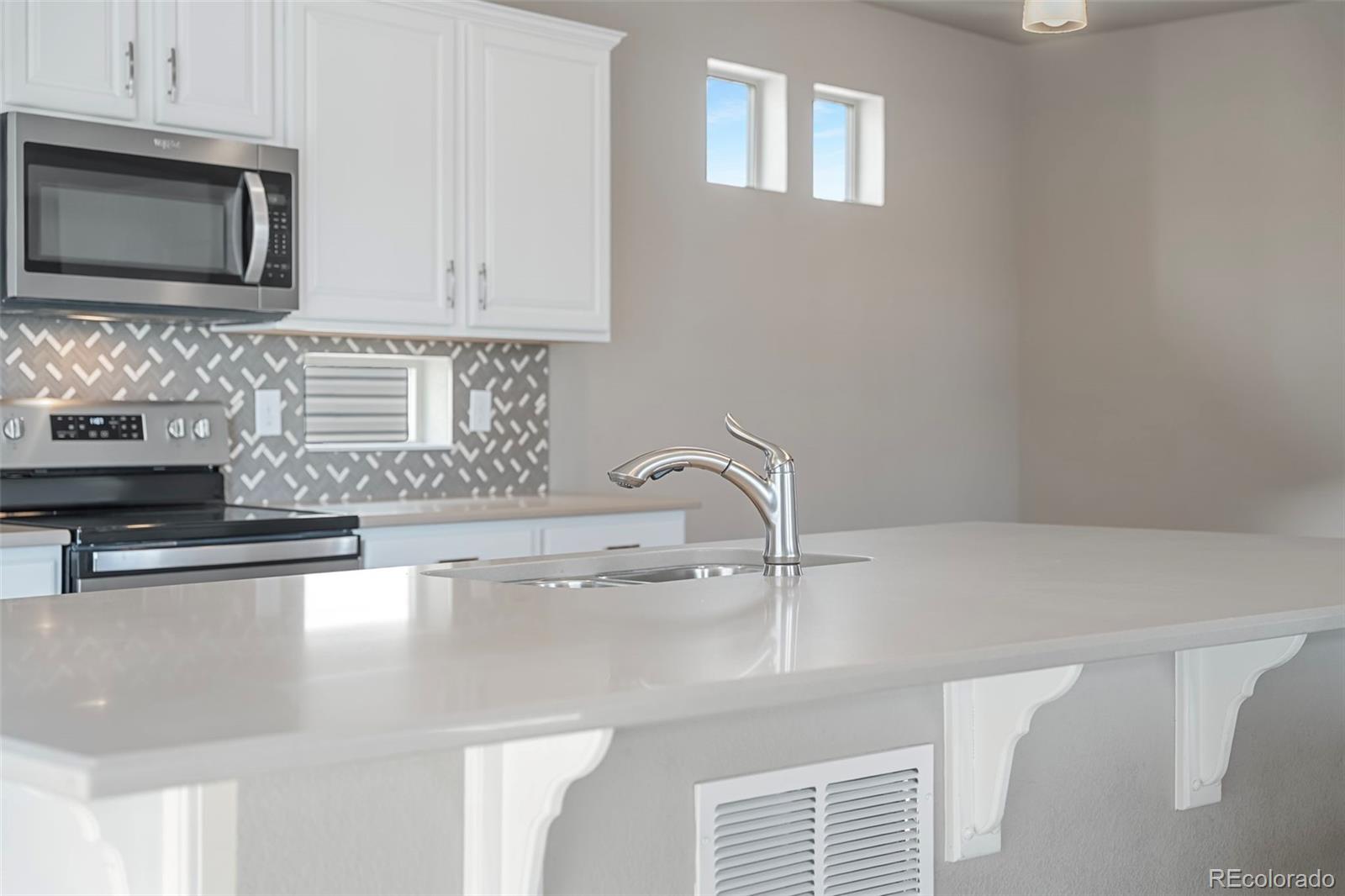 9528 Timberlake Loop Colorado Springs, CO 80927 - Photo 10 of 37 a kitchen with stainless steel appliances a sink a stove and microwave