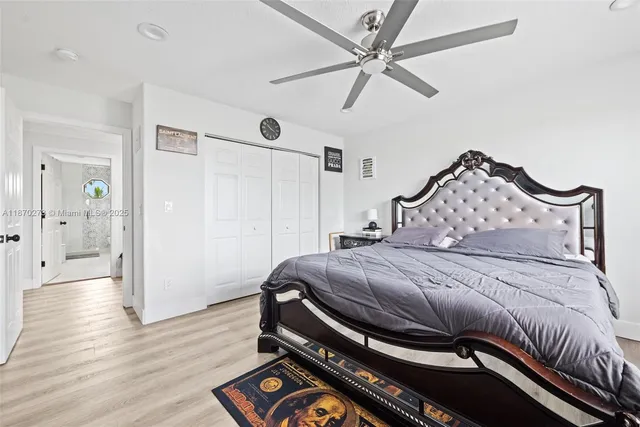 a bedroom with a bed a chandelier and dresser