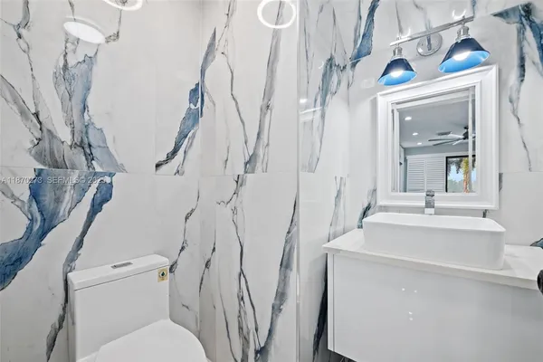 a bathroom with a granite countertop shower and a toilet