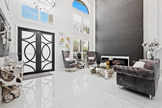 a living room with furniture a fireplace and a floor to ceiling window