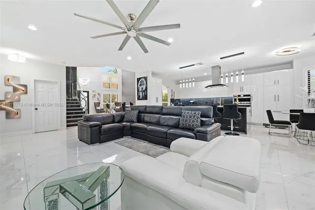 a living room with furniture kitchen view and a chandelier