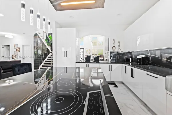 a kitchen with white cabinets and sink