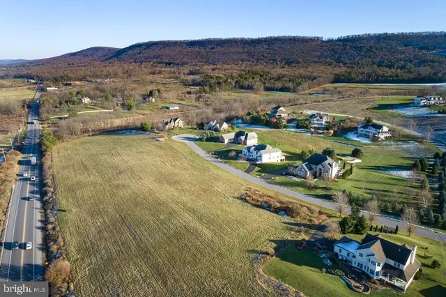 an aerial view of ocean and residential houses with outdoor space