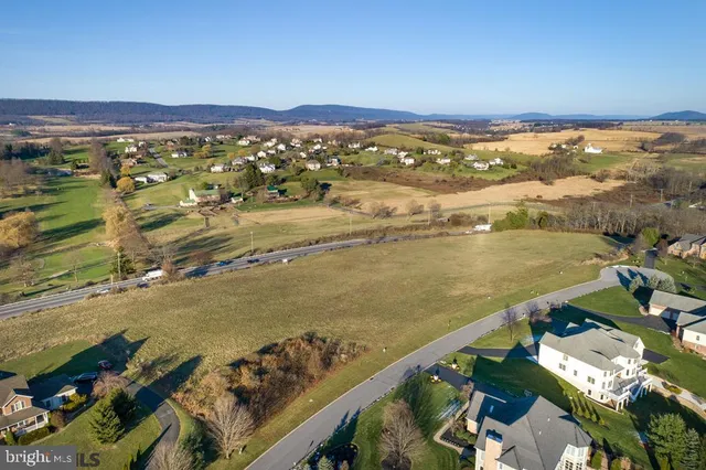 an aerial view of a house with a garden and lake view