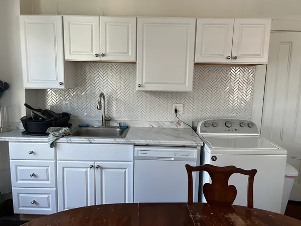 a kitchen with white cabinets and white appliances