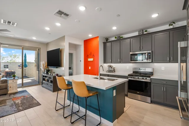 a kitchen with stainless steel appliances granite countertop a refrigerator a sink and a stove