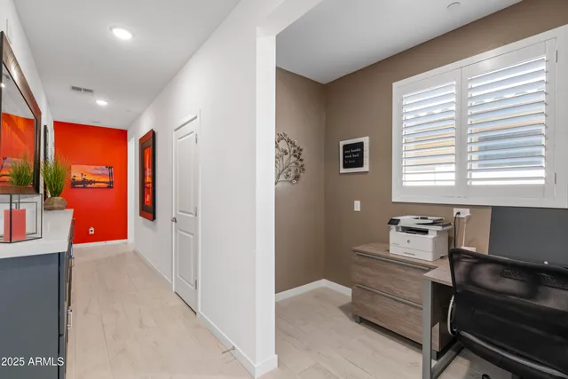 a view of a workspace with furniture and a window