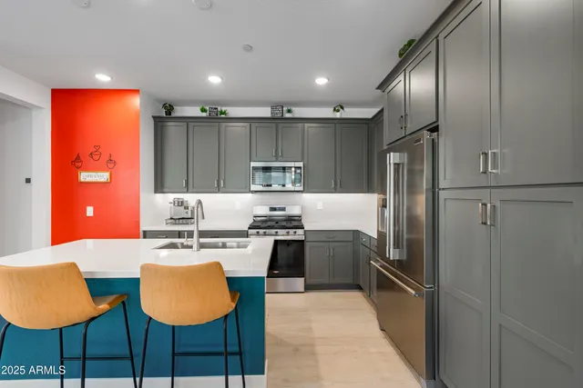 a kitchen with stainless steel appliances granite countertop a stove top oven a sink dishwasher a dining table and chairs