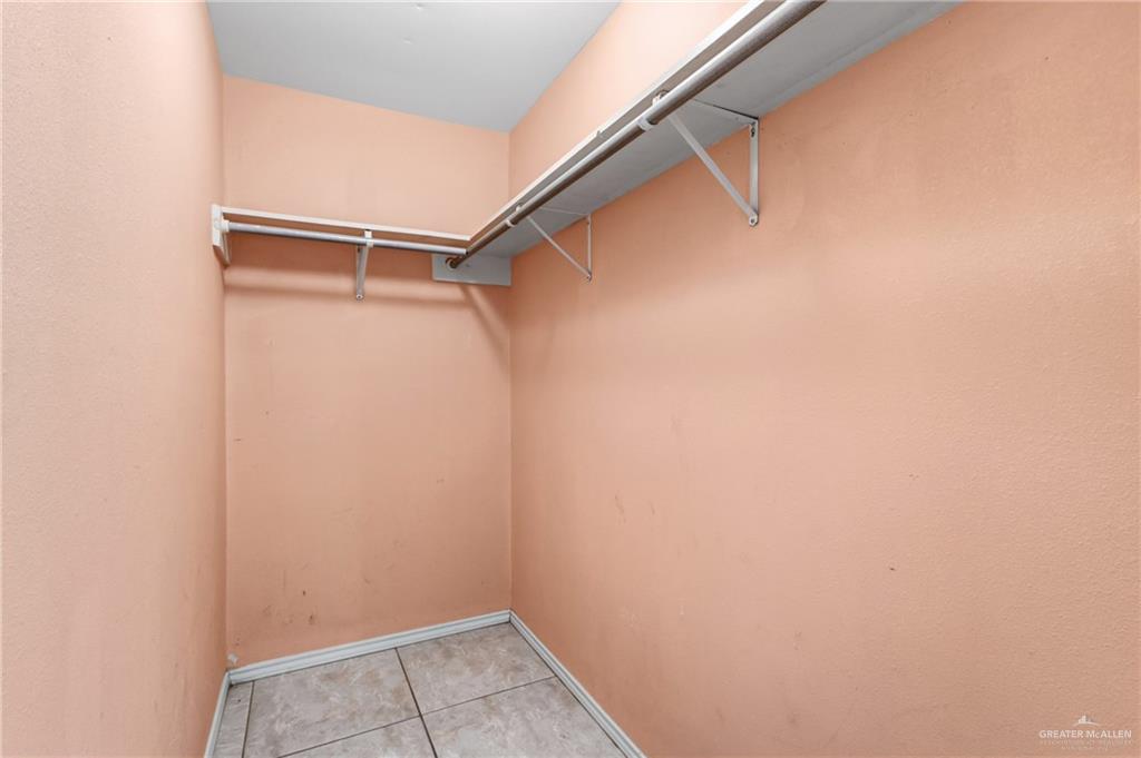402 Mockingbird Lane Edcouch, TX 78538 - Photo 19 of 25 Walk-in closet featuring light peach walls, white trim, and light-toned tile flooring