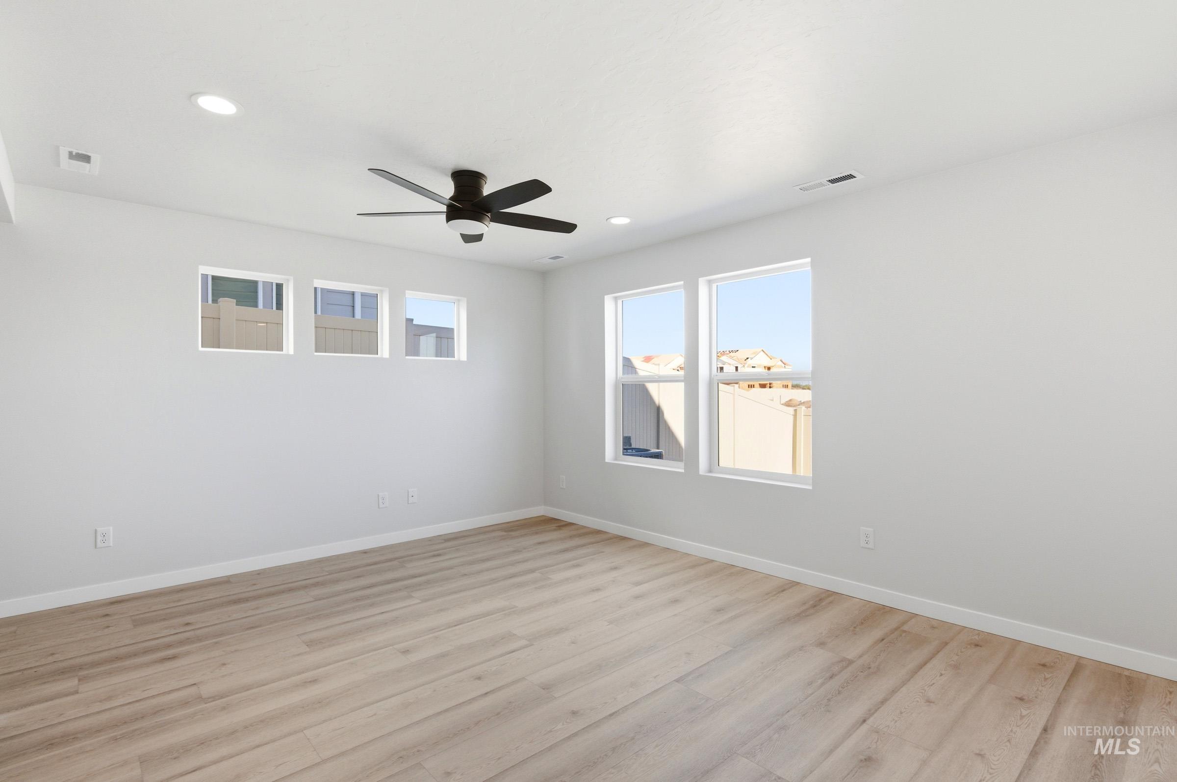 10812 Rutland Street Caldwell, ID 83605 - Photo 12 of 21 Spacious room featuring wood-finish flooring, white walls, and multiple windows