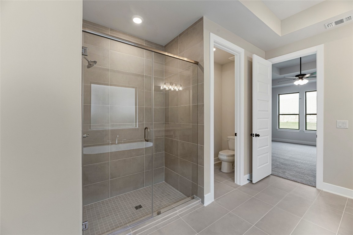 1508 Rodeo Ridge Drive Georgetown, TX 78628 - Photo 11 of 37 Bathroom with a stall shower, tile patterned flooring, and a ceiling fan