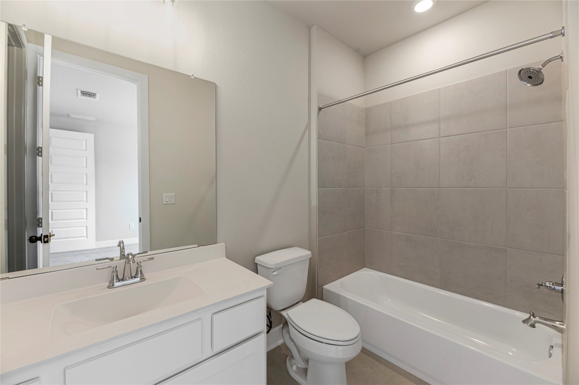 1508 Rodeo Ridge Drive Georgetown, TX 78628 - Photo 16 of 37 Bathroom with washtub / shower combination, vanity, and light tile patterned floors