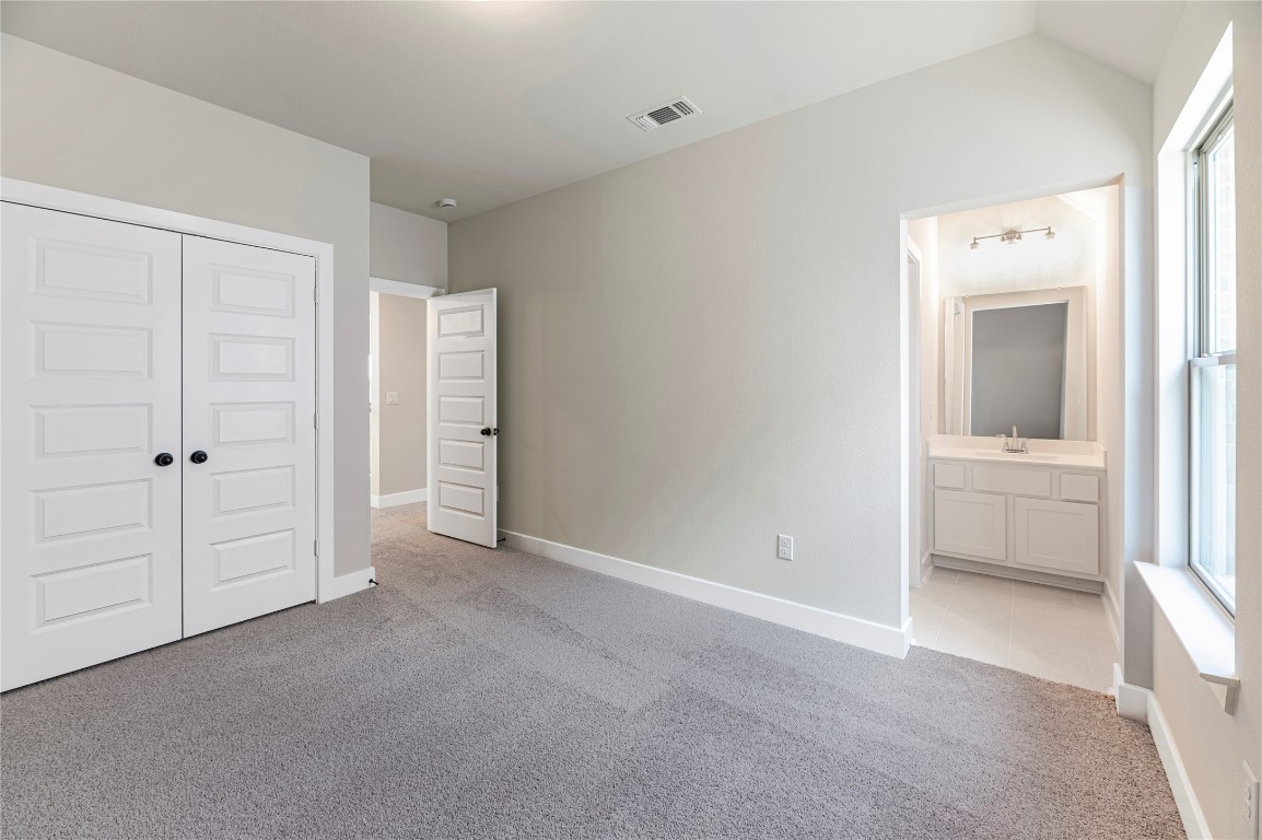 1508 Rodeo Ridge Drive Georgetown, TX 78628 - Photo 26 of 37 Unfurnished bedroom featuring light carpet, ensuite bath, and a closet
