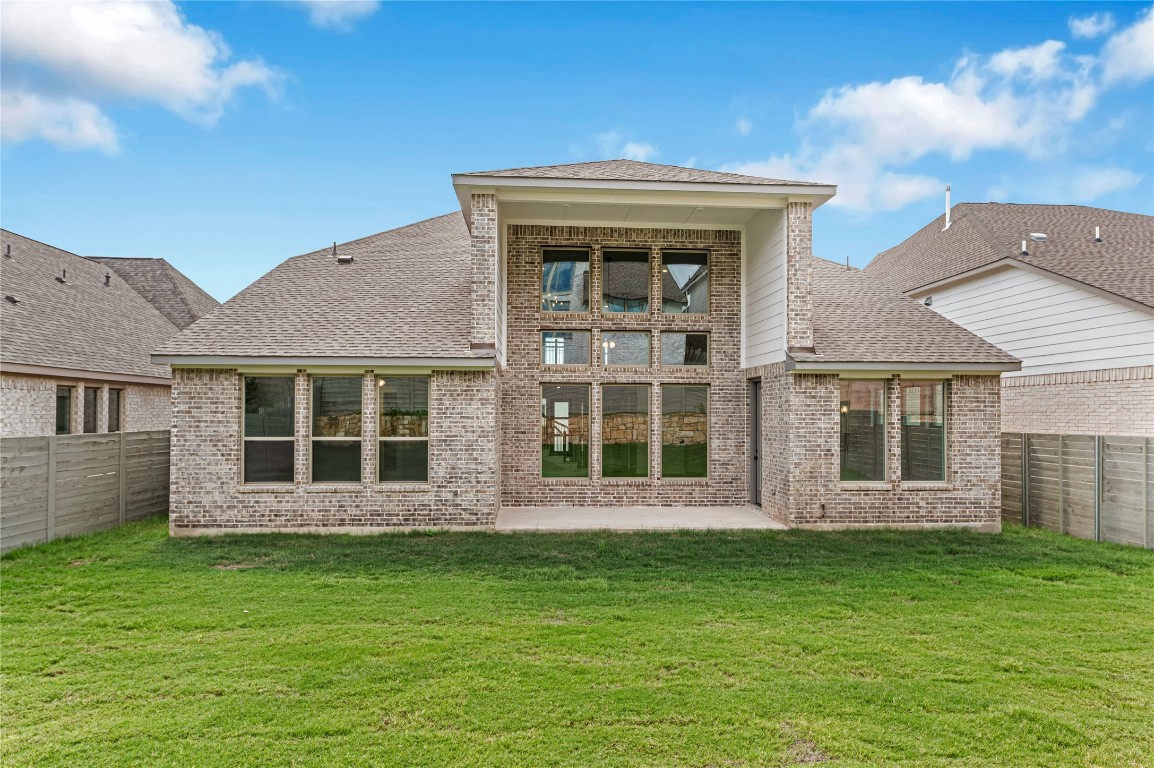 1508 Rodeo Ridge Drive Georgetown, TX 78628 - Photo 30 of 37 Rear view of house featuring a fenced backyard, roof with shingles, brick siding, and a patio