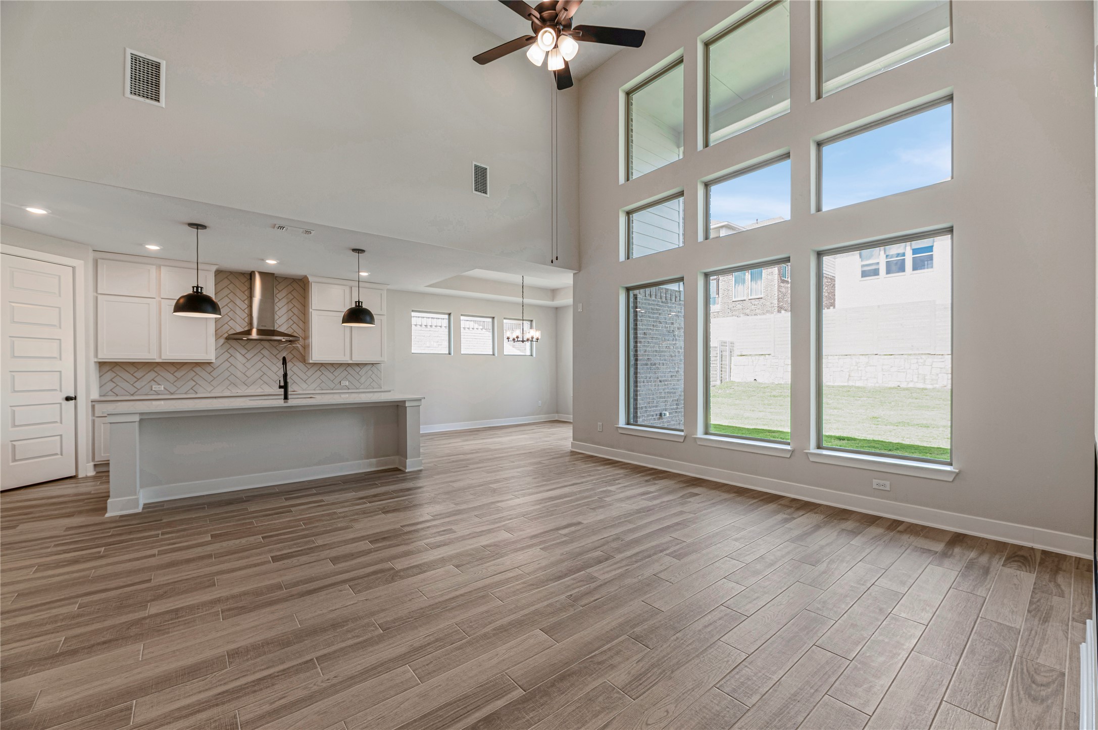 1508 Rodeo Ridge Drive Georgetown, TX 78628 - Photo 5 of 37 Unfurnished living room featuring a towering ceiling, light wood finished floors, and ceiling fan
