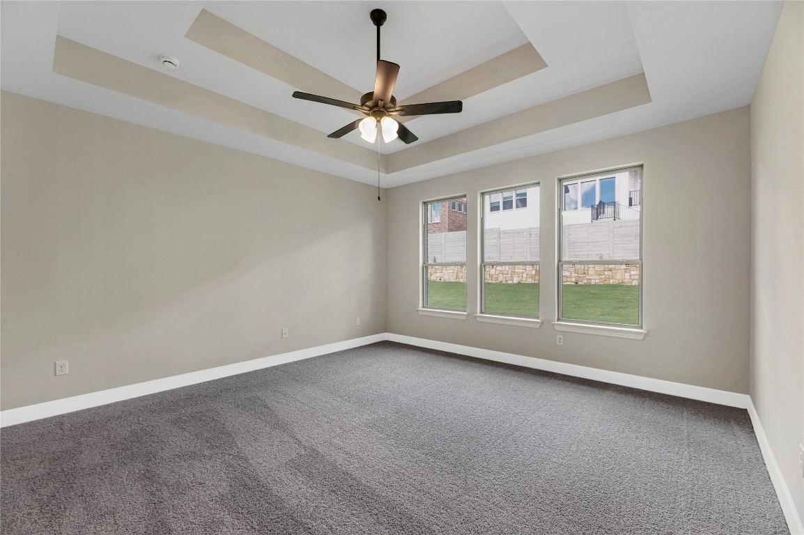 1508 Rodeo Ridge Drive Georgetown, TX 78628 - Photo 7 of 37 Empty room with a tray ceiling, carpet flooring, and ceiling fan